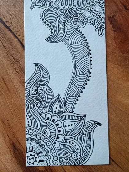 A close-up of a handmade bookmark featuring traditional paisley and floral patterns. I love getting lost in the intricate details of pen-and-ink drawing; it's a wonderful way to practice mindfulness.