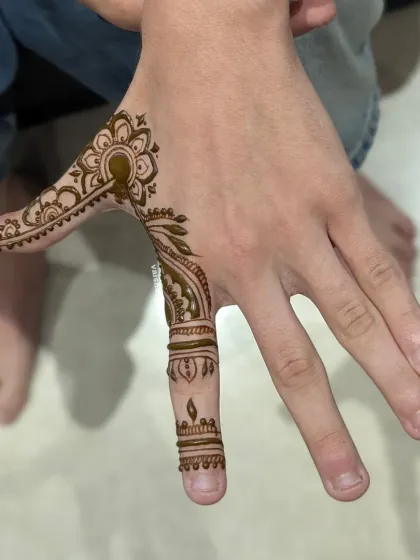 Another example of minimalist henna for men. This design is an Arabic-style vine that elegantly decorates the side of the hand and one finger.