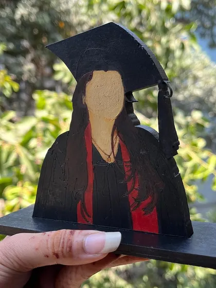 Another example of the faceless portrait style, this time for a graduate with a red sash. This style has a modern and unique charm.