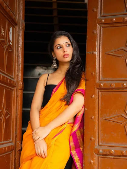 A pensive pose framed by an old wooden door. The textures and history of the location become part of the photograph's story.