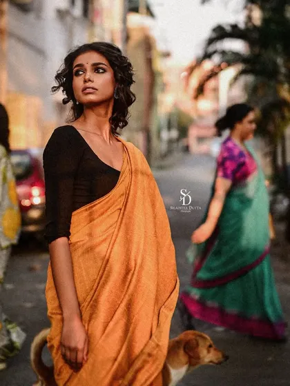 An environmental portrait of a model on a Kolkata street. Her poised figure in a saree stands out against the motion of daily life, creating a beautiful juxtaposition.