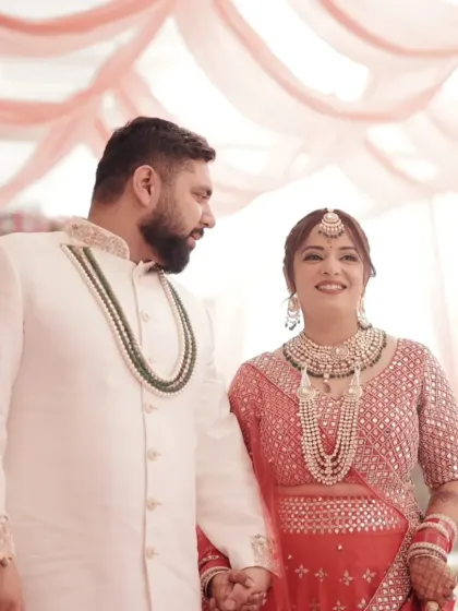 A candid shot of Abhikaran and Shipra, their happiness radiating against the soft pink and white decor of their wedding. We focus on creating an ambiance where couples can truly live in the moment.