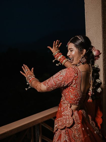 A candid shot of the bride dancing with joy on a balcony, a moment of pure, uninhibited happiness before the ceremony.