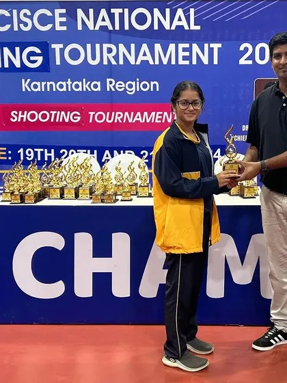 Yuvaanika receives her trophy for winning gold at the CISCE National Shooting Tournament, a proud moment for her and the academy.