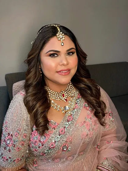 My beautiful bride ready for her big day. The makeup features a soft smokey eye and a neutral lip, perfectly complementing her intricate pink lehenga.