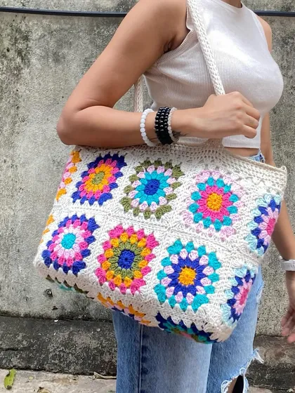 This is our spacious granny square tote bag, our absolute bestseller. It's inspired by the colorful designs you see all over Pinterest and is roomy enough to carry your world. We make each floral square by hand, and you can even customize the colors.