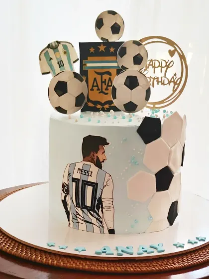 A Messi and Argentina-themed football cake, celebrating a love for the world-famous player. The design includes his jersey, the AFA logo, and multiple soccer balls.