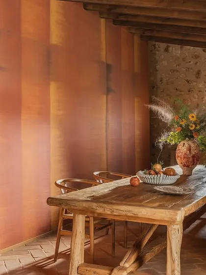 An ode to the tactile beauty of plant fibers. This wallcovering features rich, layered textures that captivate the eye and invite the hand to linger, perfectly complementing the rustic stone and wood of this dining space.