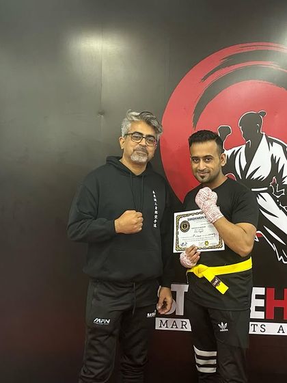 A student receives his yellow belt, a reward for his consistent hard work and training.