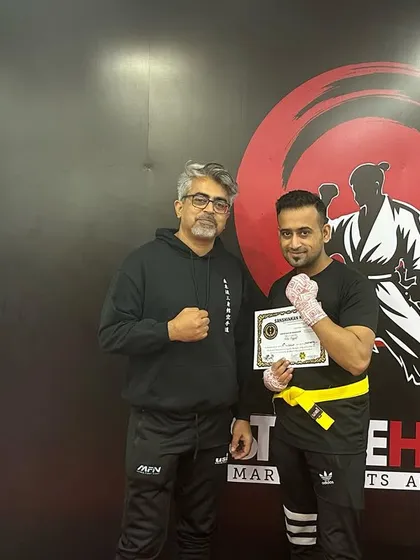 A student receives his yellow belt, a reward for his consistent hard work and training.