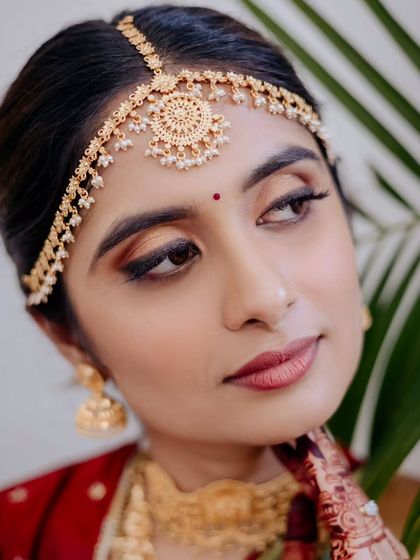 A stunning close-up of a South Indian bride. The traditional matha patti and warm, bronzy eye makeup create a look that is both classic and captivating.
