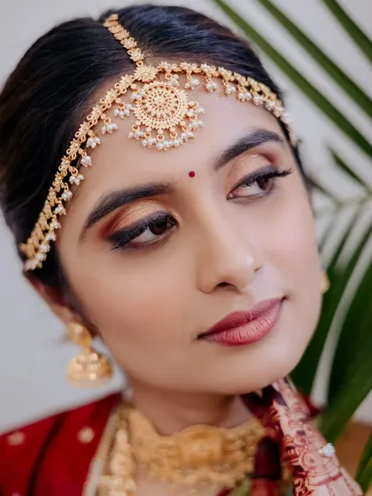 A stunning close-up of a South Indian bride. The traditional matha patti and warm, bronzy eye makeup create a look that is both classic and captivating.