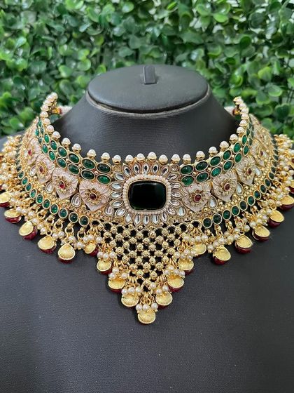 A beautiful green kundan choker set available for rent. The intricate lattice work and central black stone give it a unique and sophisticated look.