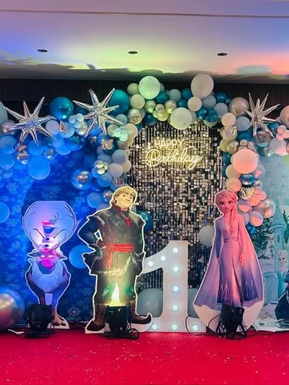 This Disney Frozen theme is perfect for creating a magical winter wonderland. I used a silver shimmer wall, hundreds of blue and white balloons, snowflake accents, and life-sized cutouts of Elsa, Anna, and Kristoff for this special first birthday party.