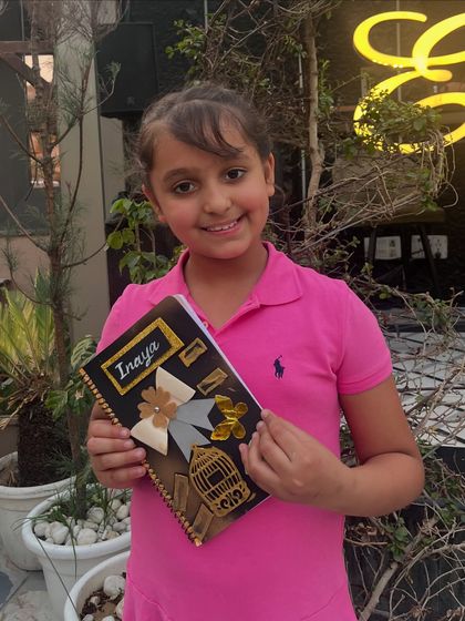 A beautifully designed diary, personalized with the student's name and elegant gold and silver embellishments.