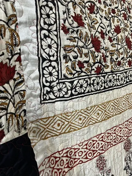 A detailed shot of the longarm quilting on the block-printed saree quilt.