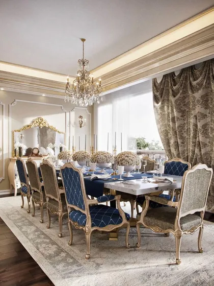 We designed this dining area to be the heart of a timeless, classical residence. The space is defined by its opulence, featuring custom chairs with intricate woodwork, a crystal chandelier, and heavy, patterned drapes that control natural light. The design amplifies the vintage character of the home, creating an elegant setting for formal gatherings.