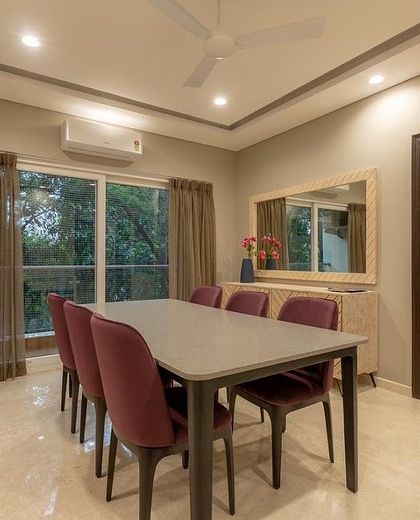 Another view of the dining room, showing its connection to a balcony that fills the space with natural light.
