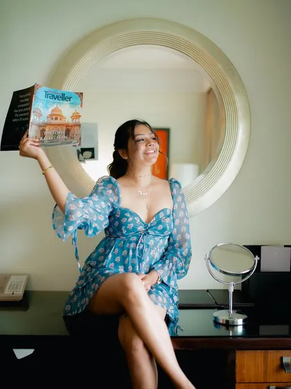 A playful and happy portrait of a model with a magazine. Her bright smile and the indoor setting create a fun and engaging lifestyle shot.