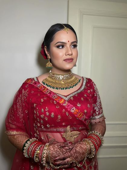 A full-length shot of the bride in her beautiful red lehenga, her makeup looking flawless and radiant.