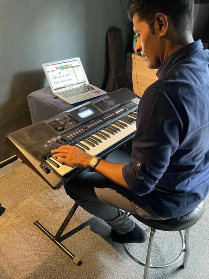 An adult student uses a laptop to follow his online keyboard lesson notes, showcasing the flexibility of our learning programs.