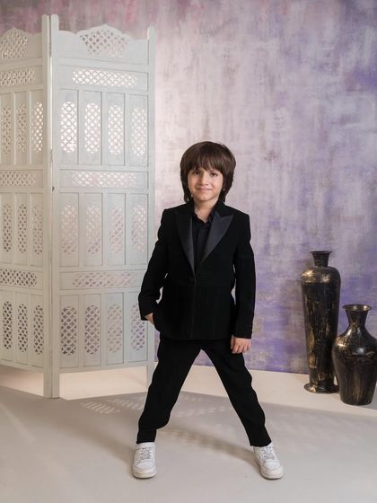 A front view of the timeless black tuxedo. This versatile outfit is a must have for any boy's wardrobe, suitable for weddings, parties, and formal family dinners.