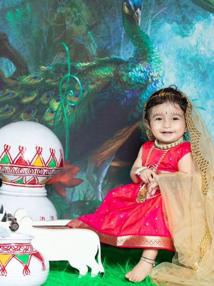This little Radha is sitting gracefully, with a peacock and matkas in the background.