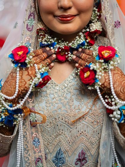 A close-up shot focusing on the bride's intricate floral jewellery and henna. These details are an essential part of the story of her bridal preparations.