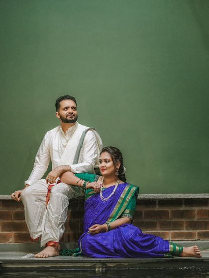 A beautiful portrait of a couple at their baby's naming ceremony, dressed in traditional attire.