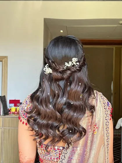 The same beautiful Haldi hairstyle from a different angle, showing the intricate braid and the shimmer of the pearl accessories.