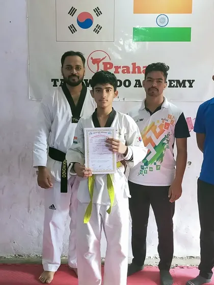 A yellow belt student with his first Taekwondo certificate, a keepsake he will cherish for years.