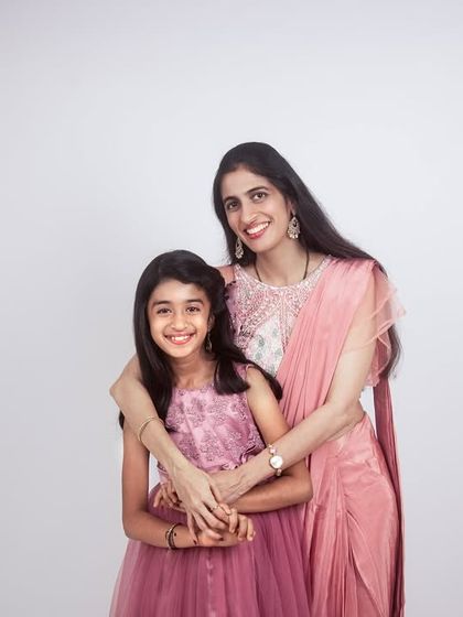 A beautiful portrait of a mother and daughter in the studio. Their coordinated outfits and loving embrace showcase their special bond.
