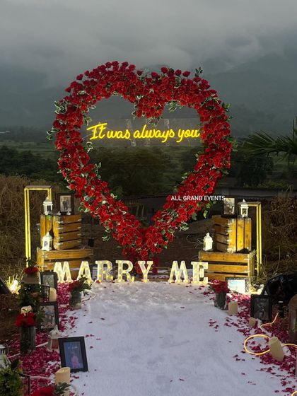 A closer look at the details of our grand proposal setup. The combination of the glowing 'Marry Me' letters, the neon sign, and the lush rose arch creates a picture-perfect backdrop.
