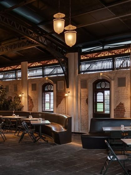 A seating area with custom curved banquettes and exposed brick walls. This combination of refined furniture and raw materials is a signature part of my design approach.