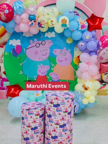 A Peppa Pig party with a circular backdrop and a pastel balloon arch. The themed plinths add another layer of character detail.