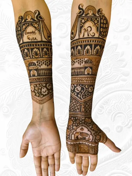 A unique bridal design incorporating the couple's initials and travel story (Canada/USA) into the artwork. The other arm features a traditional palace and floral patterns.