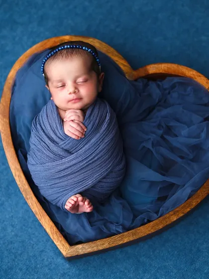 This shot captures the full swaddle and the baby's tiny feet peeking out, a detail that parents always love to remember.