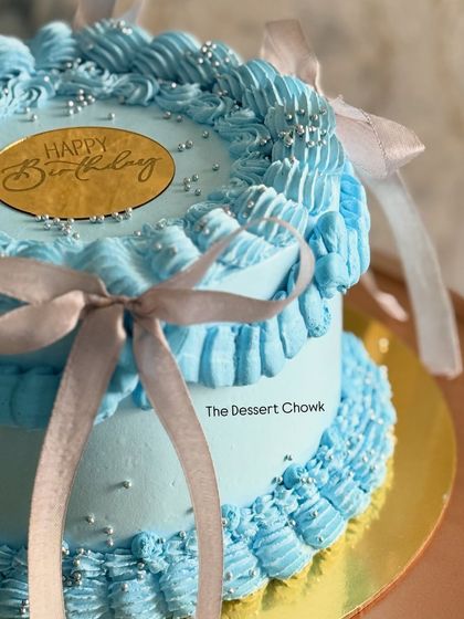 A close-up of a blue Lambeth-style tall cake, showing the intricate ribbon and ruffle piping. This was a chocolate mousse cake for a birthday.