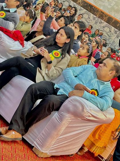 As a guest at the school event, watching the performances. It is a privilege to be part of such community gatherings and to support local institutions.