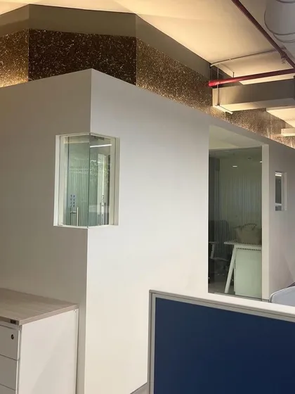 A corner detail in the Umicore office, showing the intersection of glass walls and an accent panel made from recycled materials. This reflects the company's focus on circular materials technology.