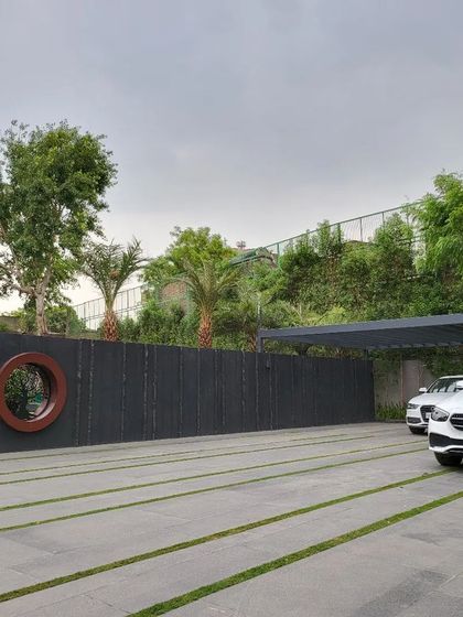 The impressive driveway and feature wall of a private residence in Kanpur. We utilize Indian stone in various finishes to create texture and visual interest, complemented by a tree of life mural that adds an artistic, meaningful touch.