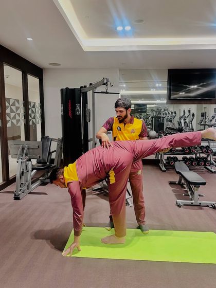 Working with a cricketer on a balancing pose. This improves proprioception and stability, which is vital for preventing ankle and knee injuries in sports.