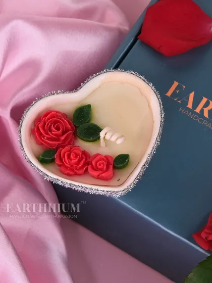 This heart-shaped candle is adorned with tiny red roses, a delicate and beautiful gesture of love.