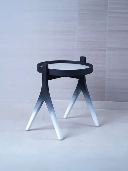 We designed this side table to be a piece of functional sculpture, featuring a striking black-to-white gradient on its tripod legs. Its minimalist form and unique finish make it a modern accent piece that adds an artistic touch to a space.