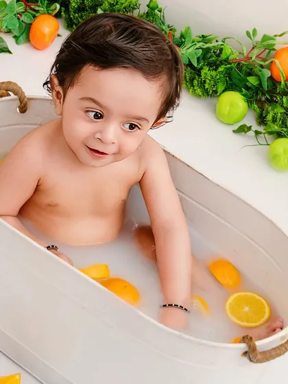 Sunny, bright, and everything nice. A close-up of a baby enjoying a citrus-filled milk bath, a unique and beautiful milestone session.