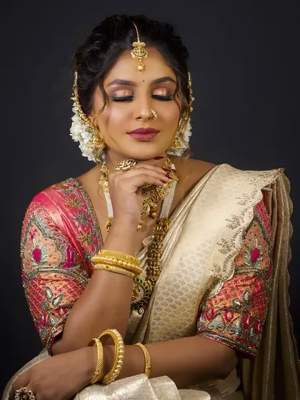 This image captures a moment of quiet beauty, focusing on the flawless makeup and the intricate design of the temple jewellery.