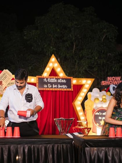 It's not a party without some games. The parents-to-be enjoy a fun activity at their movie-themed baby shower, with the custom-designed stage providing the perfect backdrop.