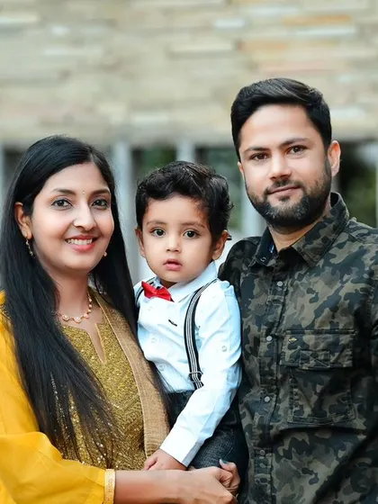 A classic family portrait taken outdoors, showcasing their coordinated outfits and happy smiles.