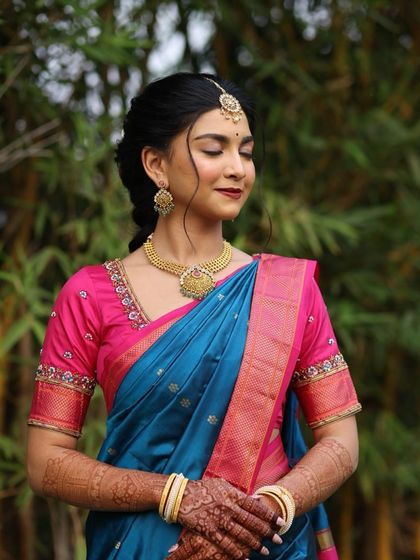 A close-up of the bride's peaceful expression. The makeup is subtle, with a focus on flawless skin and a classic red lip.