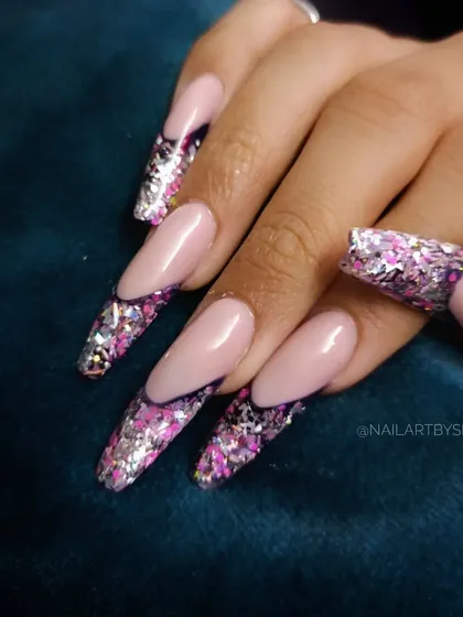 A still image of the dramatic and sparkly freestyle glitter French manicure.